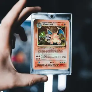 A hand holding a charizard pokemon trading card